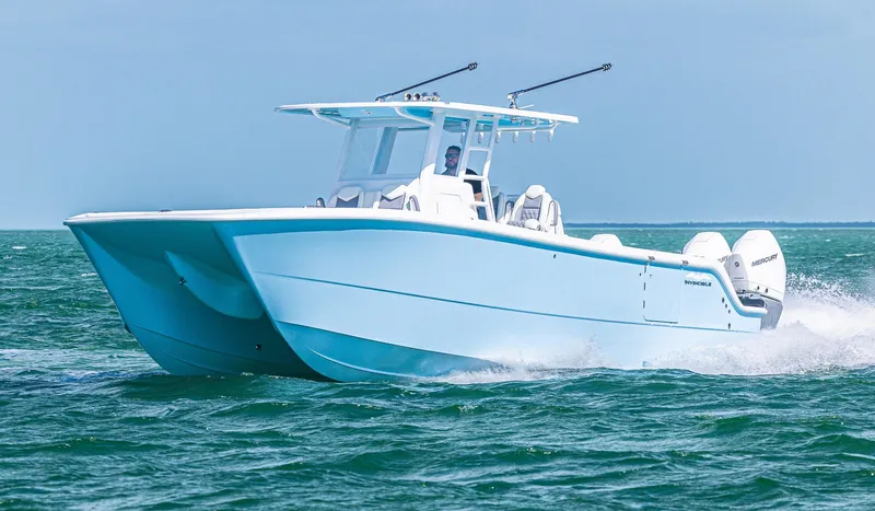  Yacht Photos Pics 2025 Invincible 35 Catamaran cruising on open water, showcasing sleek design and powerful engines.
