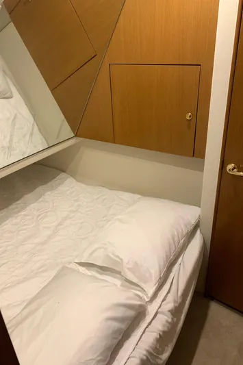 Fryedays Off Yacht Photos Pics Cozy bedroom in 2003 Ocean Yachts 43 Super Sport, featuring wood paneling and white bedding.