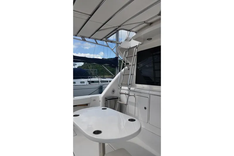  Yacht Photos Pics 2007 Bertram 510 Convertible yacht interior with table and ladder, docked at marina.