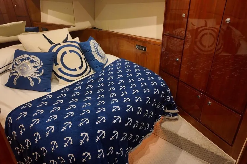 Yacht Photos Pics Luxurious 2007 Bertram 510 Convertible cabin with nautical-themed bedding and wooden cabinetry.