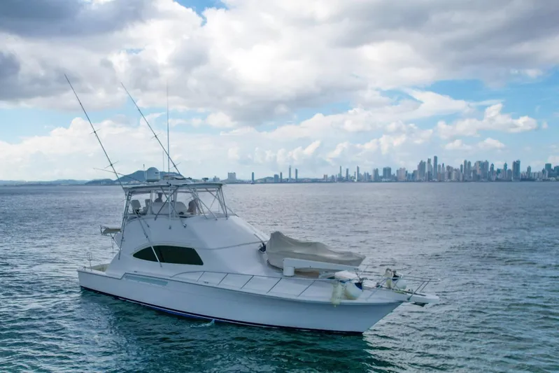  Yacht Photos Pics 2007 Bertram 510 Convertible yacht on calm waters with city skyline in background.