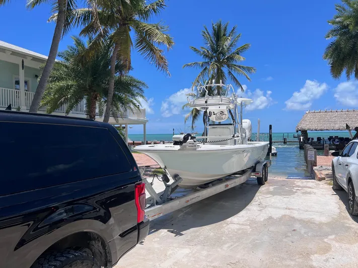  Yacht Photos Pics Canyon Bay 28h boat on trailer near tropical waterfront, 2022 model.