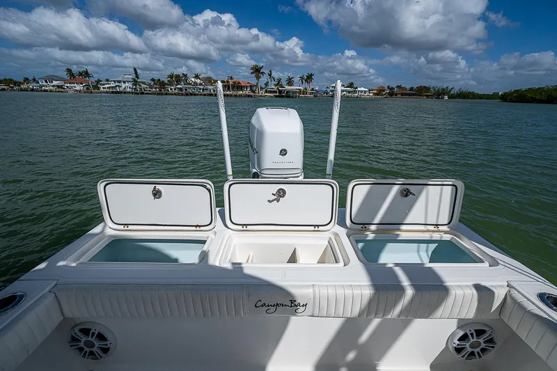  Yacht Photos Pics 2022 Canyon Bay 28h boat with open storage compartments on a sunny day.