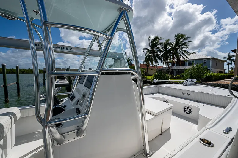  Yacht Photos Pics 2022 Canyon Bay 28h boat interior with console and seating, docked by palm trees.