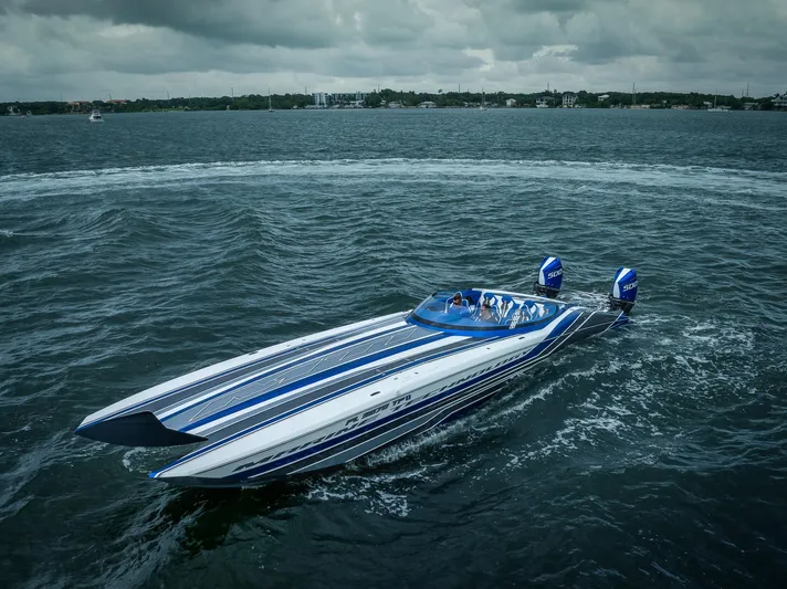  Yacht Photos Pics 2024 MTI 440X powerboat cruising on a lake under cloudy skies.