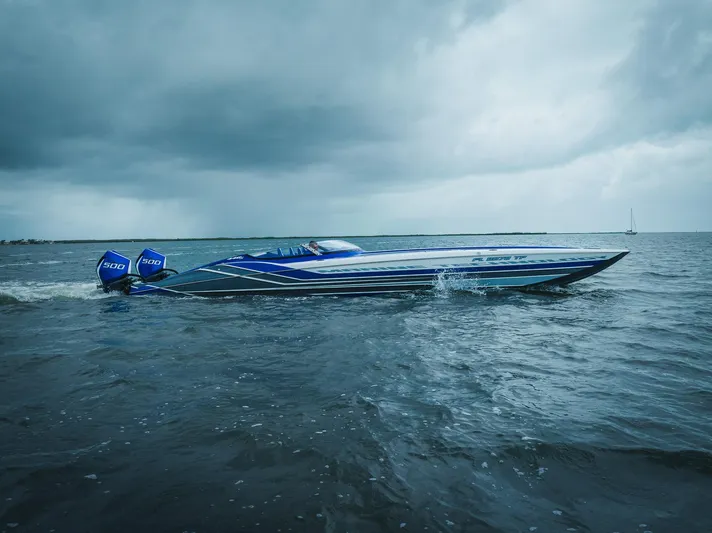  Yacht Photos Pics 2024 MTI 440X speedboat cruising on open water under cloudy skies.