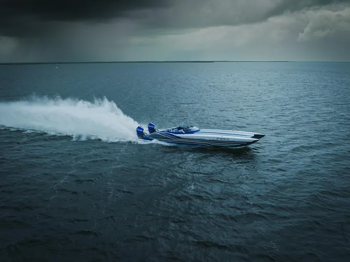  Yacht Photos Pics 2024 MTI 440X speedboat racing on open water under cloudy skies.