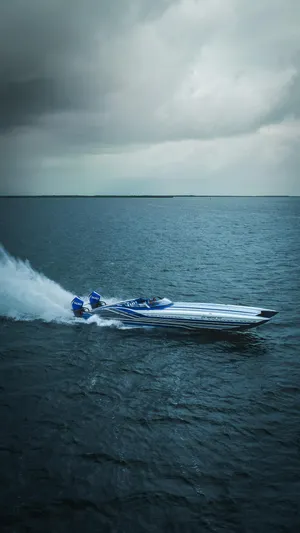  Yacht Photos Pics 2024 MTI 440X speedboat cruising on open water under cloudy skies.