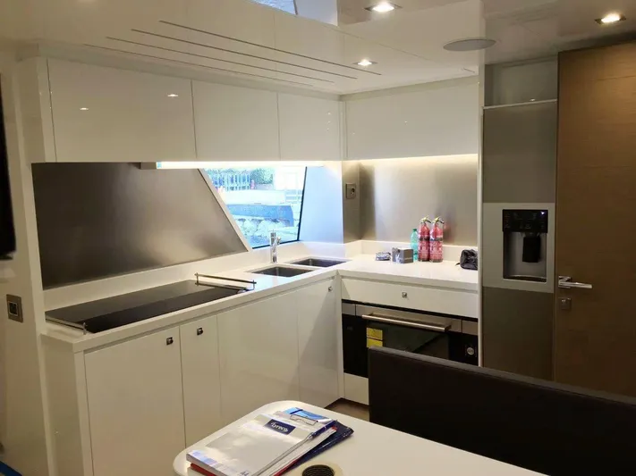  Yacht Photos Pics Modern kitchen interior on 2017 Custom Line Navetta 28 yacht, featuring sleek white cabinetry.