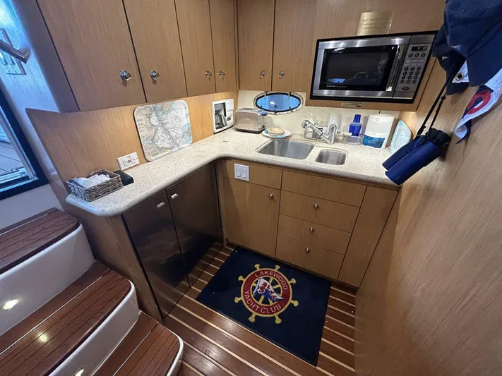 Native Dancer Yacht Photos Pics 2002 Tiara Yachts 3800 Open kitchen with wood cabinets, microwave, and sink.