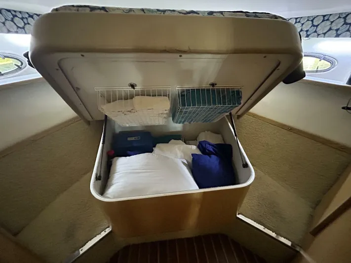 Native Dancer Yacht Photos Pics Tiara Yachts 3800 Open 2002 cabin storage with bedding and organized shelves.