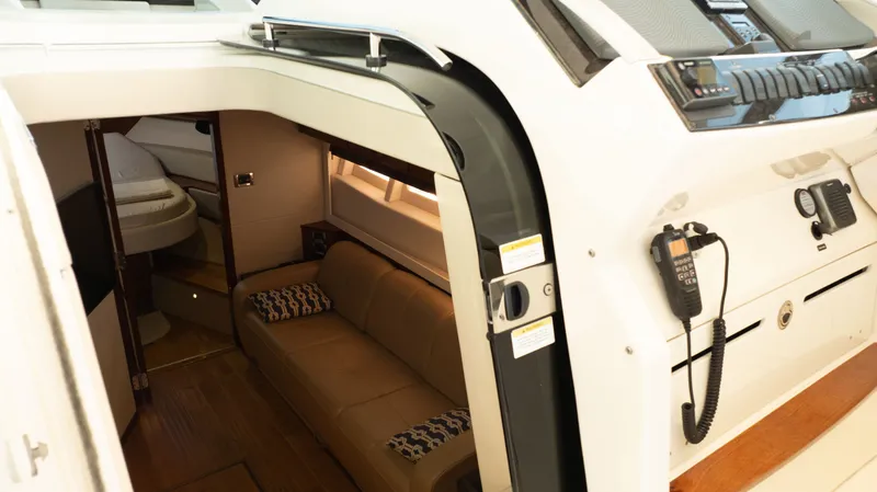  Yacht Photos Pics Interior view of 2014 Sea Ray 410 Sundancer yacht, featuring a cozy cabin and control panel.