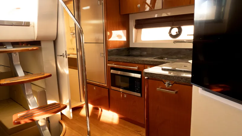  Yacht Photos Pics Interior of 2014 Sea Ray 410 Sundancer yacht, featuring modern kitchen and wooden stairs.