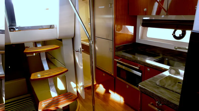  Yacht Photos Pics Luxurious interior of 2014 Sea Ray 410 Sundancer yacht with modern kitchen and wooden stairs.