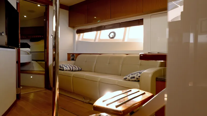  Yacht Photos Pics Luxurious interior of 2014 Sea Ray 410 Sundancer yacht with beige sofa and wooden accents.