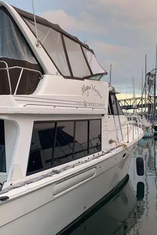 Magna Veritas Yacht Photos Pics 1996 Bayliner 4788 yacht docked at marina, featuring sleek design and spacious cabin.