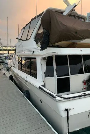 Magna Veritas Yacht Photos Pics 1996 Bayliner 4788 yacht docked at sunset, featuring a spacious cabin and sleek design.