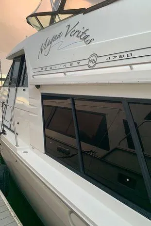 Magna Veritas Yacht Photos Pics 1996 Bayliner 4788 yacht docked, showcasing sleek design and windows.