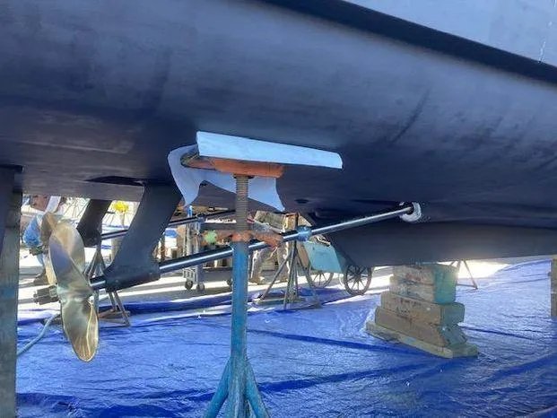 Magna Veritas Yacht Photos Pics 1996 Bayliner 4788 yacht under maintenance, showing propeller and hull supported by stands.