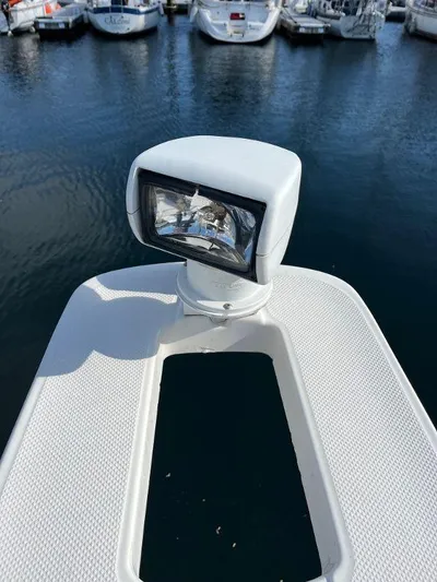 Magna Veritas Yacht Photos Pics Close-up of a 1996 Bayliner 4788 spotlight on a boat deck in a marina.