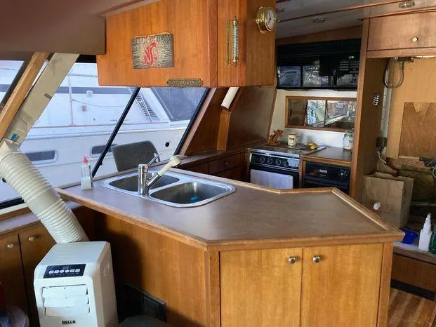 Magna Veritas Yacht Photos Pics Interior of 1996 Bayliner 4788 yacht with kitchen and wooden cabinetry.