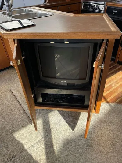 Magna Veritas Yacht Photos Pics 1996 Bayliner 4788 interior with vintage Sony TV in wooden cabinet.