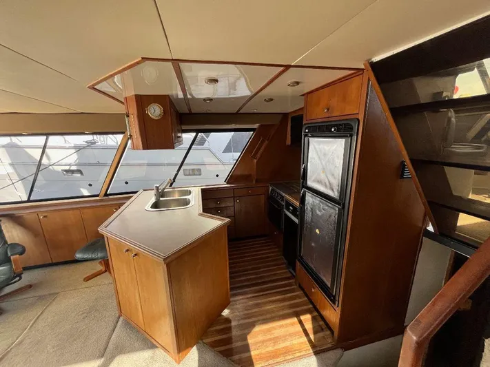 Magna Veritas Yacht Photos Pics Interior of 1996 Bayliner 4788 yacht with kitchen area and wooden cabinetry.