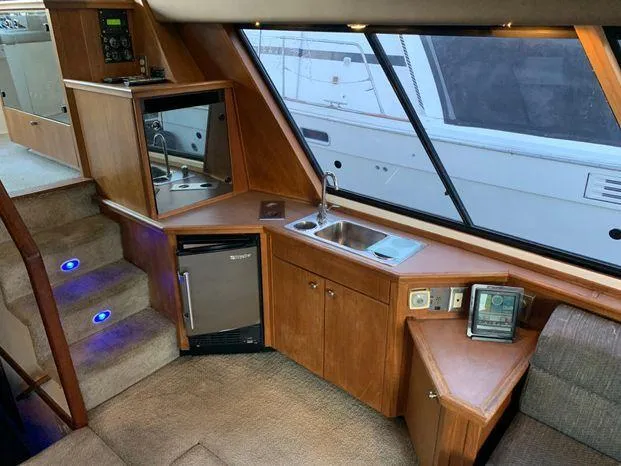 Magna Veritas Yacht Photos Pics Interior of a 1996 Bayliner 4788 yacht with kitchenette and stairs.