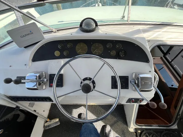 Magna Veritas Yacht Photos Pics 1996 Bayliner 4788 helm with Garmin navigation, steering wheel, and control levers.