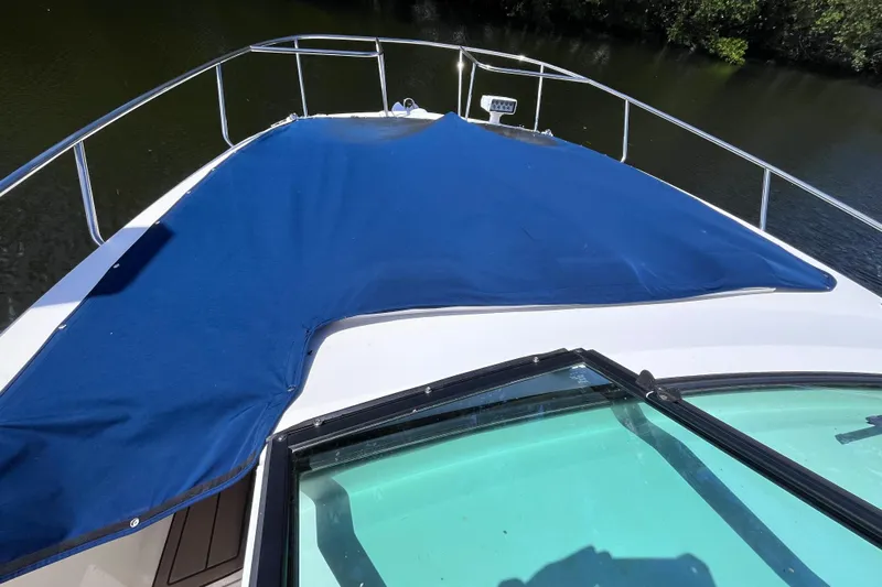 Blu Yacht Photos Pics 2020 Sea Ray Sundancer 320 Outboard with blue deck cover on calm water.