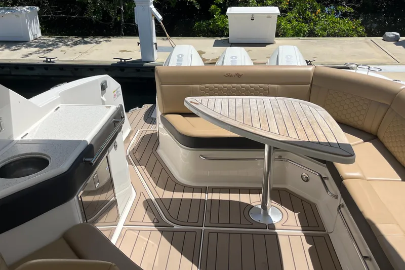 Blu Yacht Photos Pics 2020 Sea Ray Sundancer 320 Outboard interior with seating and table, docked at marina.