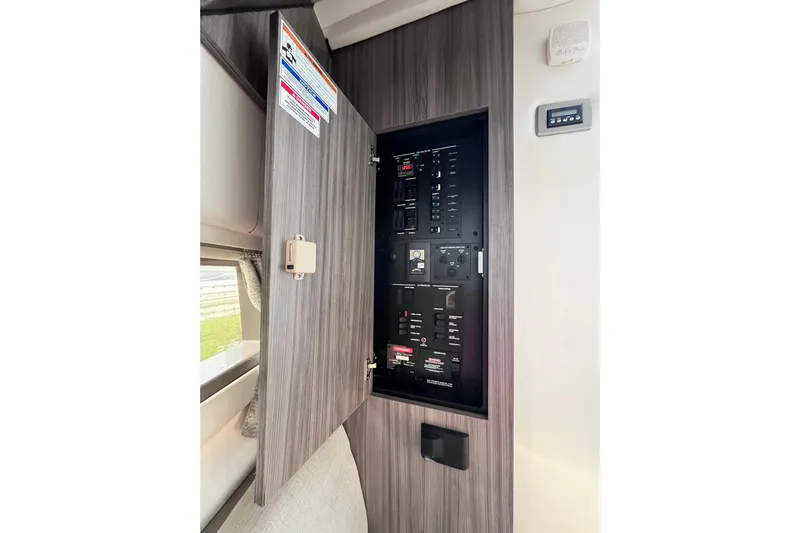 Blu Yacht Photos Pics Electrical panel inside 2020 Sea Ray Sundancer 320 Outboard boat, with open cabinet door.