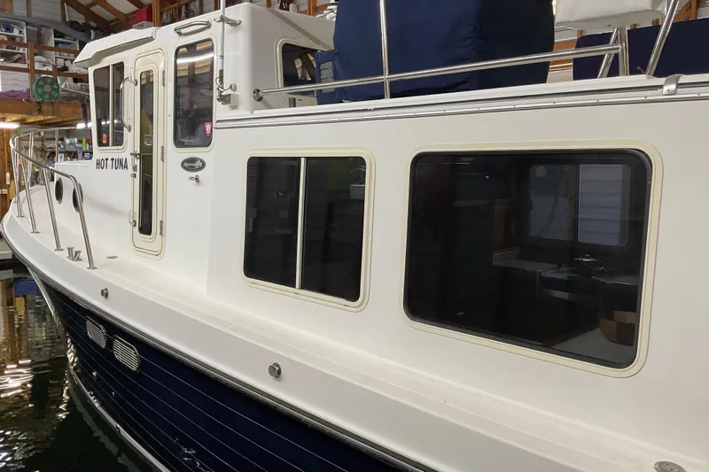 Hot Tuna Yacht Photos Pics 2002 American Tug Hull #24 docked indoors, showcasing sleek design and large windows.