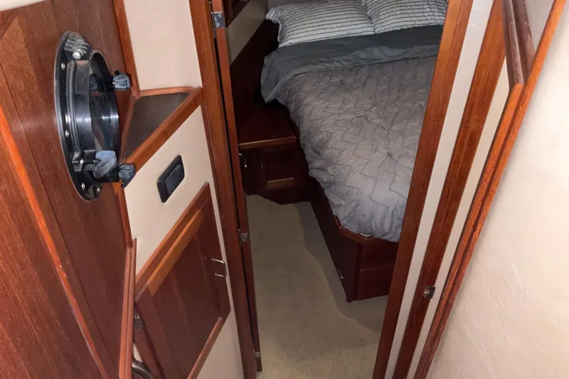 Hot Tuna Yacht Photos Pics Cozy cabin interior of 2002 American Tug Hull #24 with bed and wooden accents.