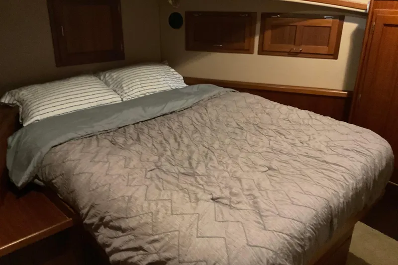 Hot Tuna Yacht Photos Pics Cozy bedroom in 2002 American Tug Hull #24 with striped pillows and quilted bedding.