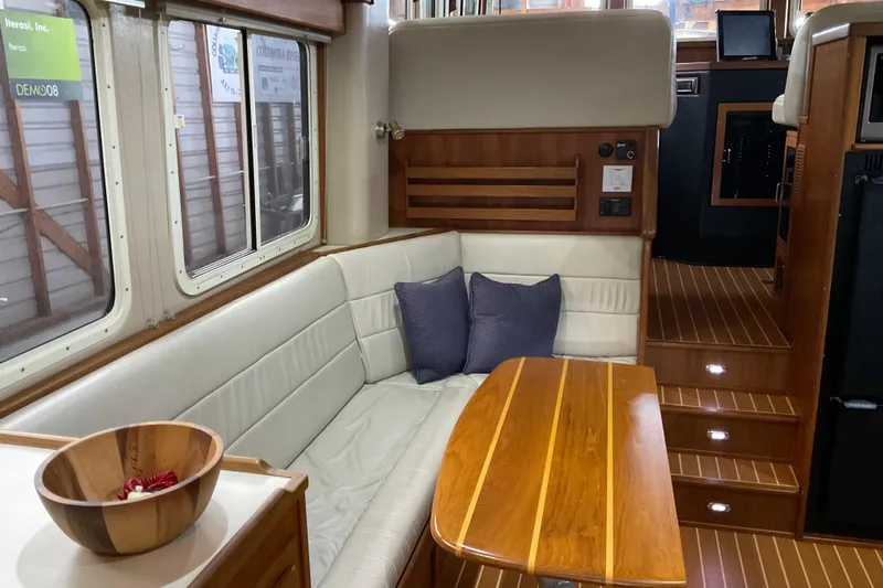 Hot Tuna Yacht Photos Pics Interior of 2002 American Tug Hull #24 with wooden table and cushioned seating.
