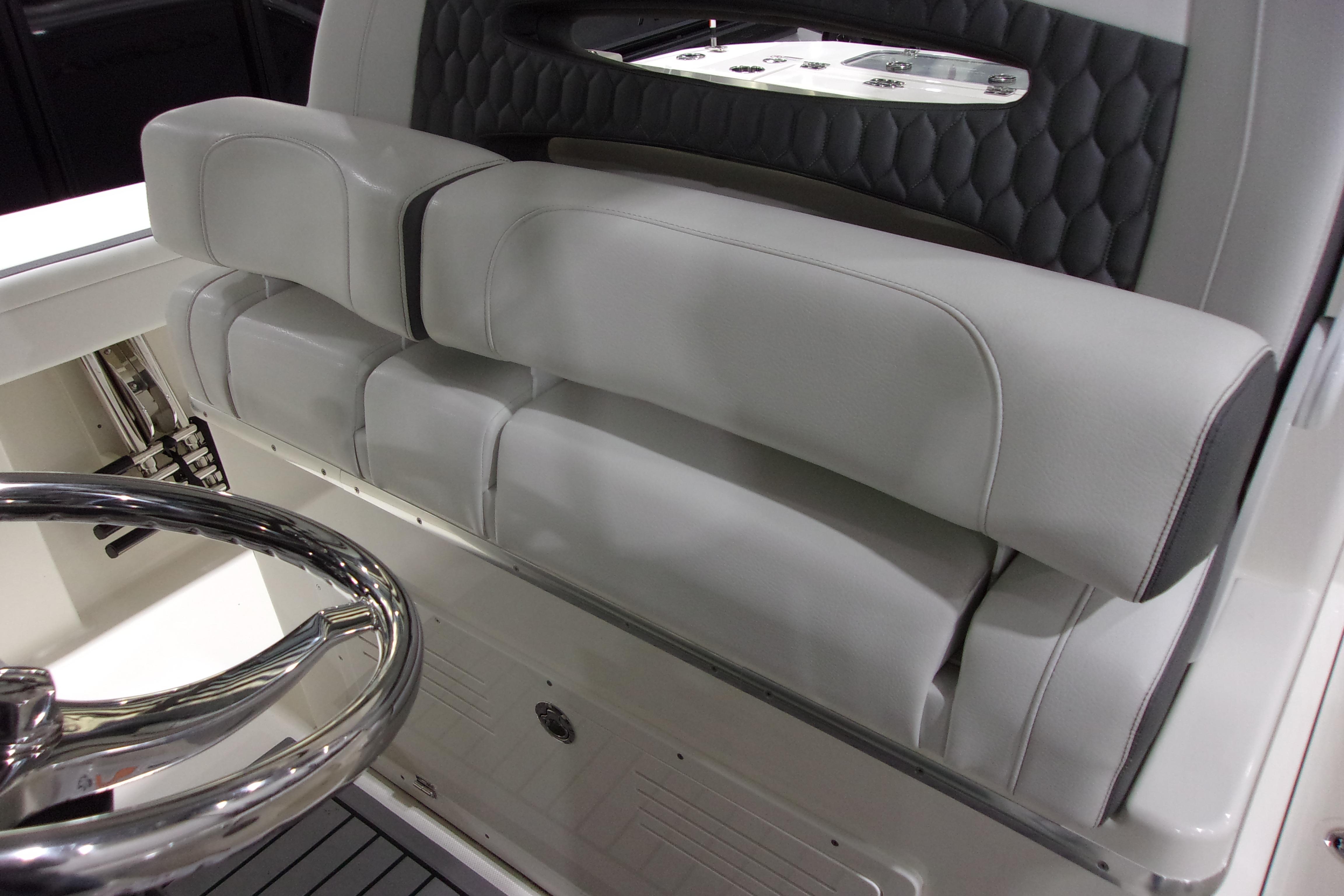 2026 Cobia 305 Center Console boat interior with sleek steering wheel and cushioned seating.