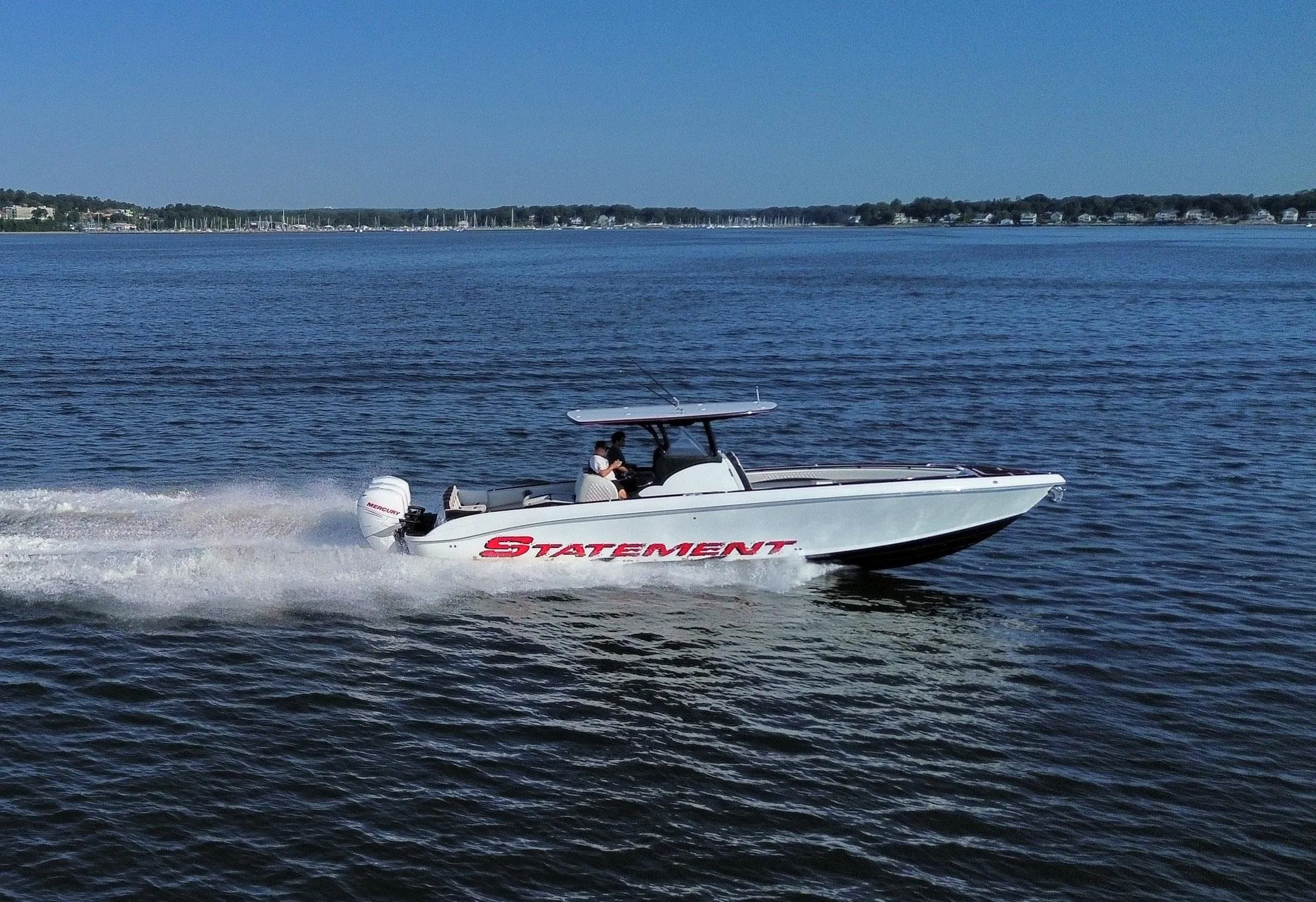2017 Statement 380 Open boat cruising on a calm lake under a clear blue sky.