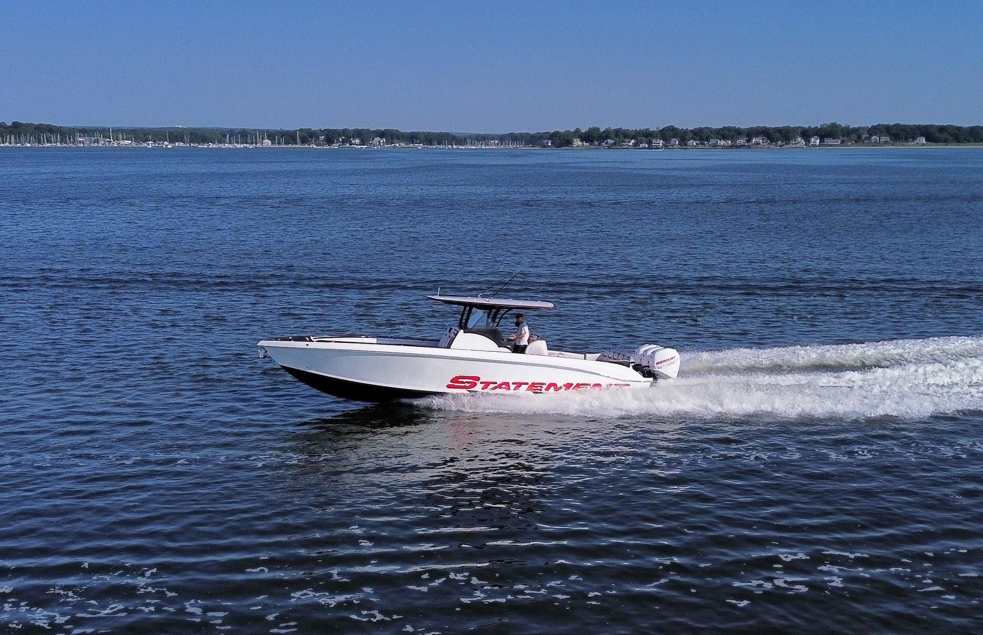 2017 Statement 380 Open boat cruising on a calm lake under a clear blue sky.