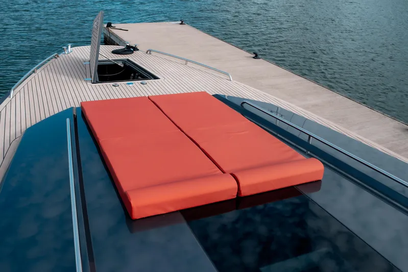 Explorer 1 Yacht Photos Pics 2024 Ridas 62 yacht with red sunbed on deck, docked by the water.