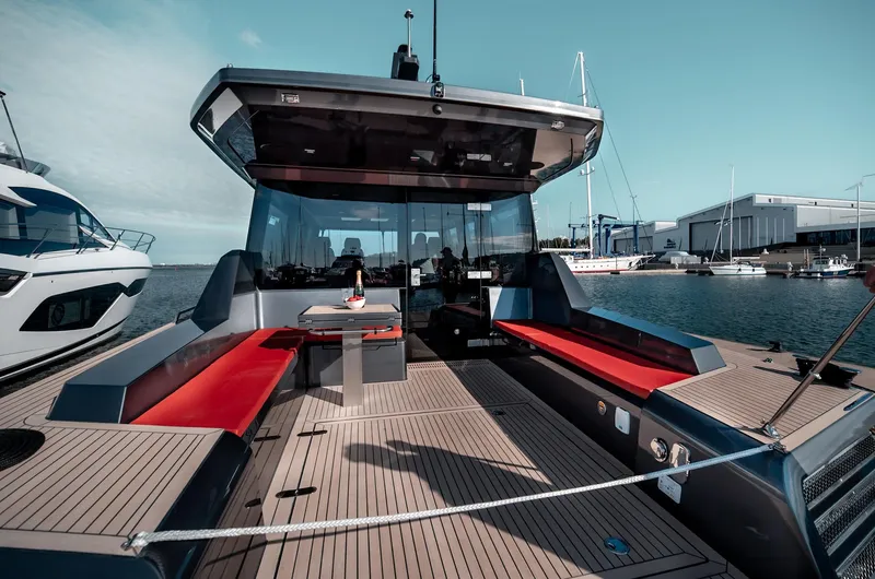 Explorer 1 Yacht Photos Pics 2024 Ridas 62 yacht with spacious deck, red seating, and modern design in a marina setting.