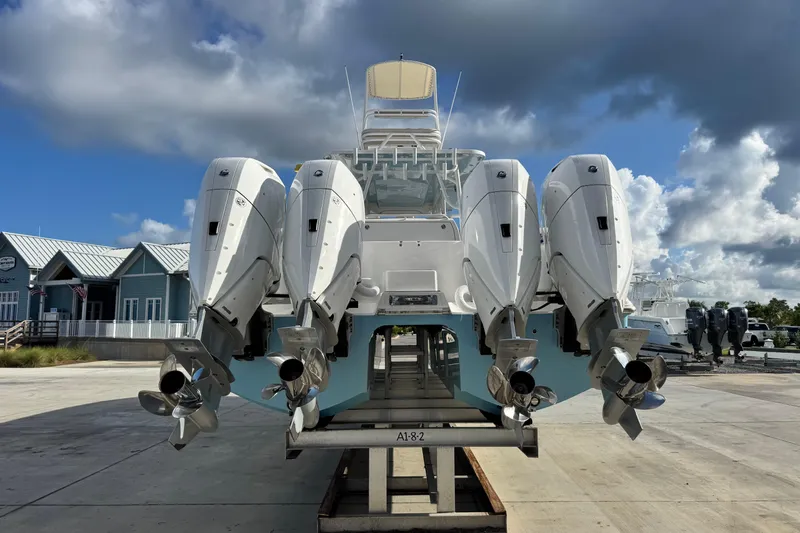  Yacht Photos Pics 2020 Invincible 40 Catamaran with four powerful outboard engines, docked under a cloudy sky.