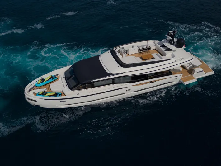 Mini K2 Yacht Photos Pics Luxury yacht Extra X99 FAST 2022 cruising on open water, featuring sleek design and jet skis.