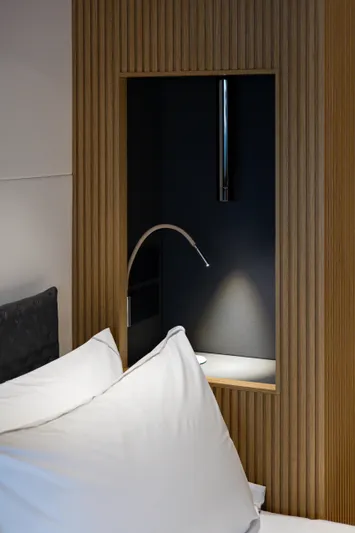 Mini K2 Yacht Photos Pics Modern bedroom with wooden paneling, sleek reading light, and plush white pillows. Extra X99 FAST, 2022.