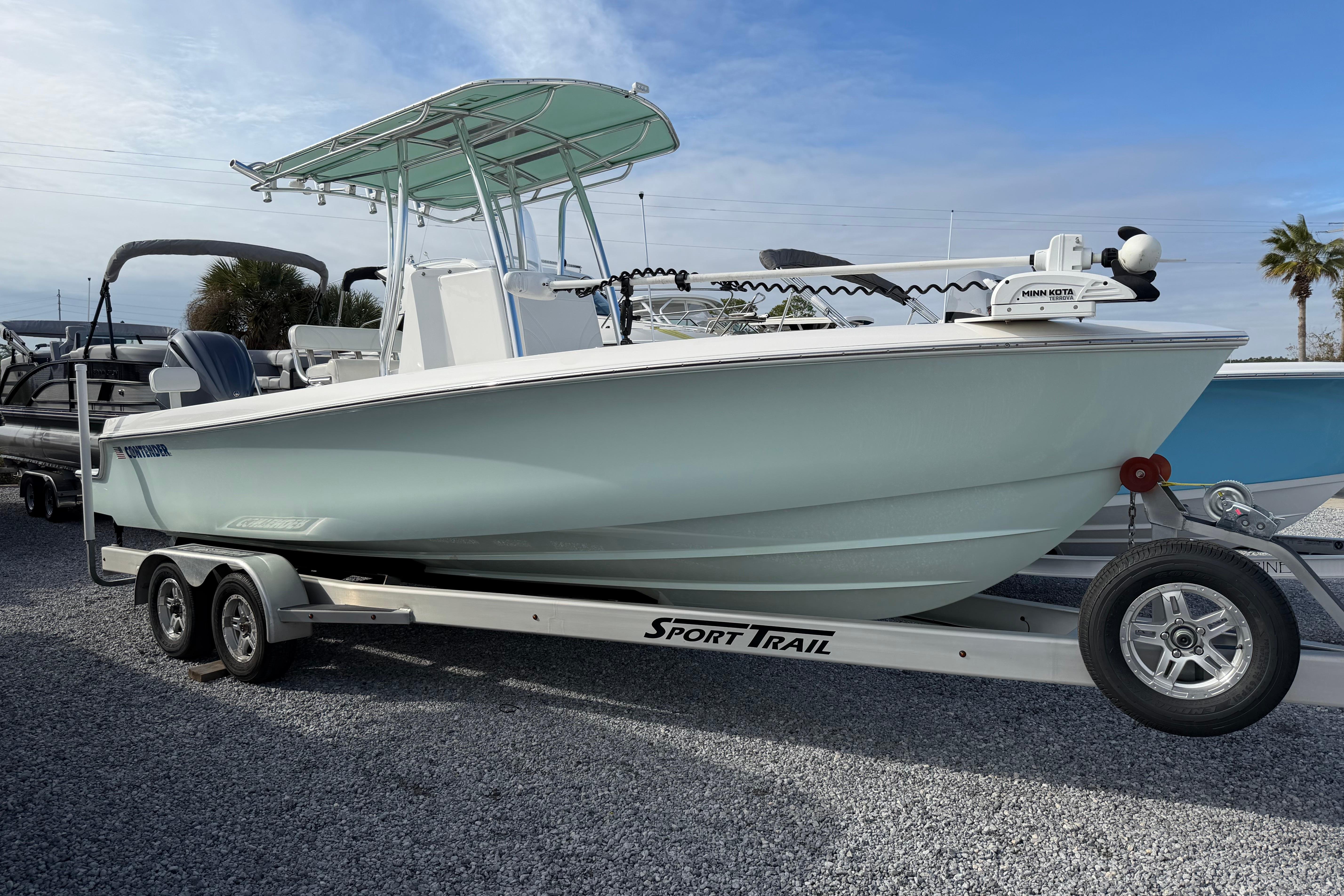 2023 Contender 24 Sport boat on trailer, parked outdoors under blue sky.