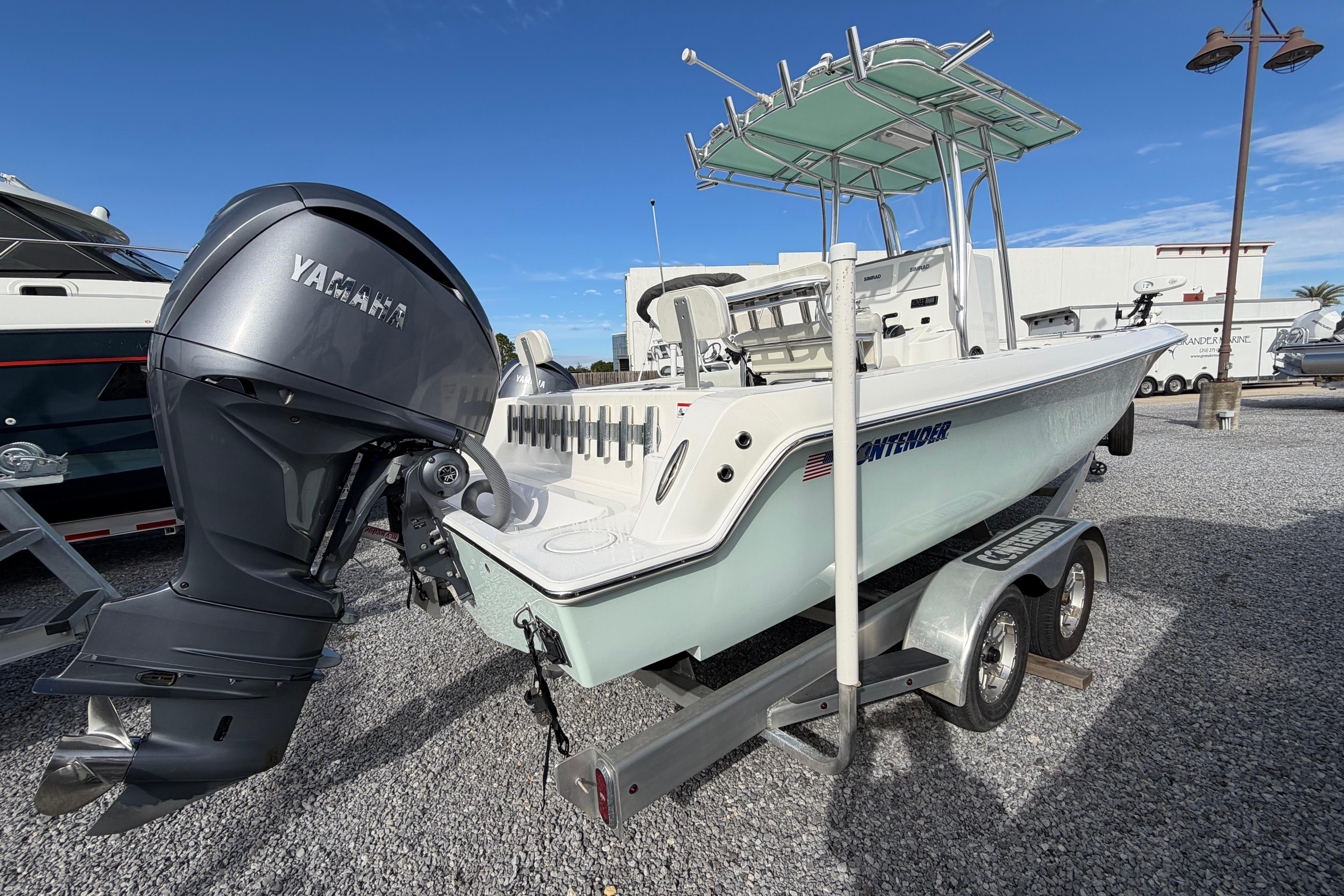 2023 Contender 24 Sport boat with Yamaha outboard engine on trailer, parked outdoors.