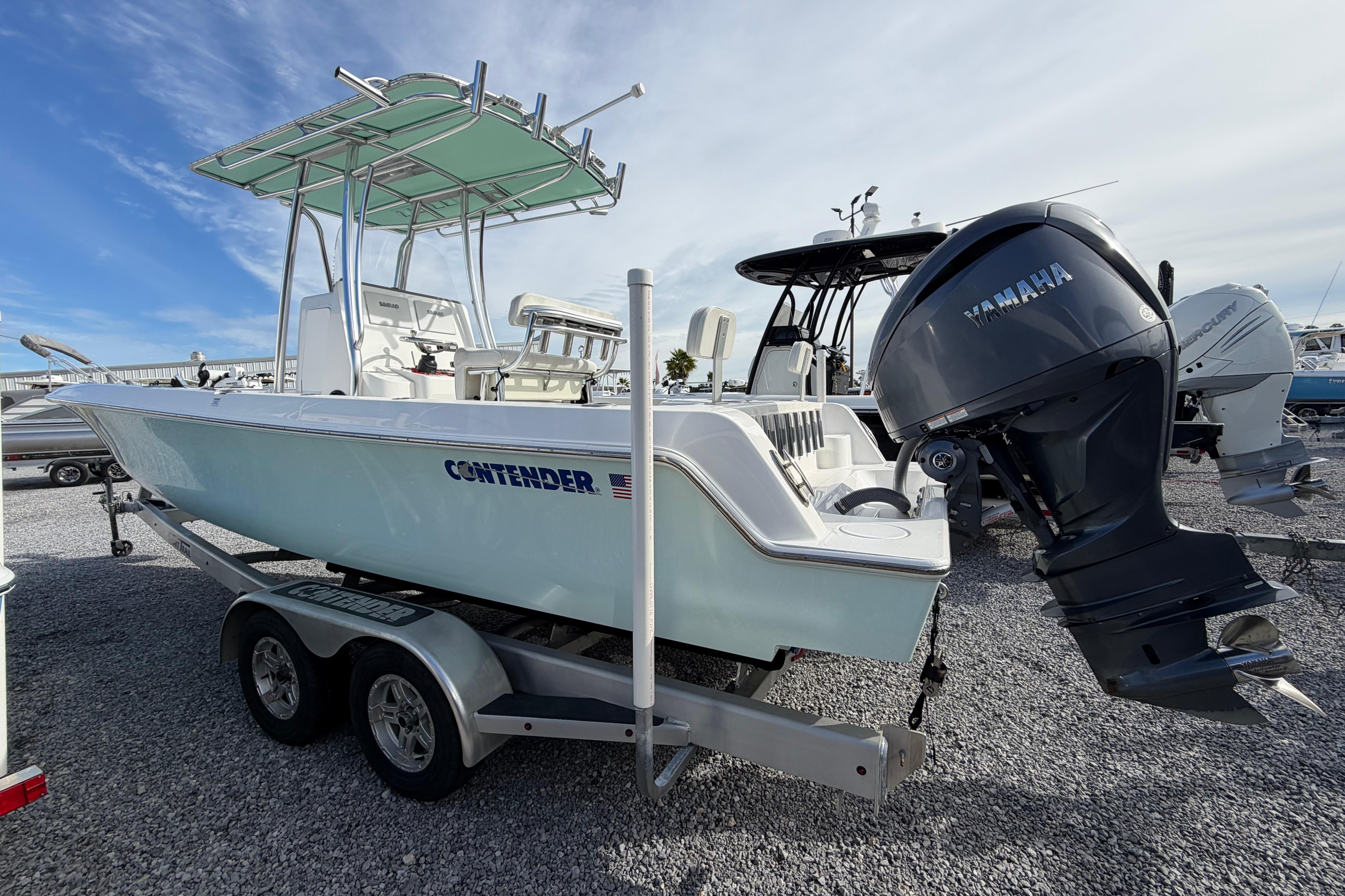 2023 Contender 24 Sport boat with Yamaha engine on trailer, parked on gravel.