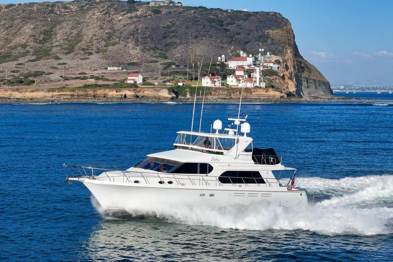 Encore Yacht Photos Pics 2006 Ocean Alexander 64 Pilothouse yacht cruising near a rocky coastline.
