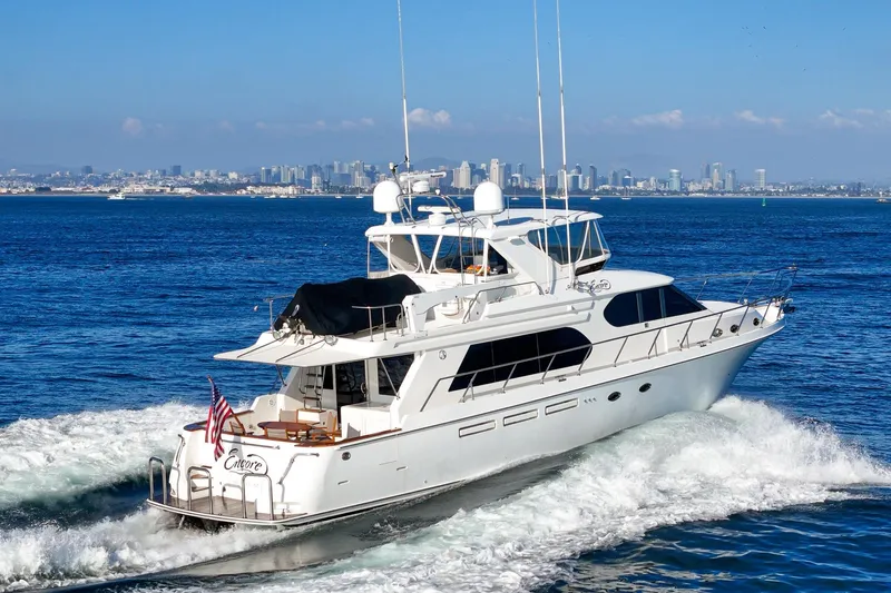Encore Yacht Photos Pics Luxury 2006 Ocean Alexander 64 Pilothouse yacht cruising near city skyline.