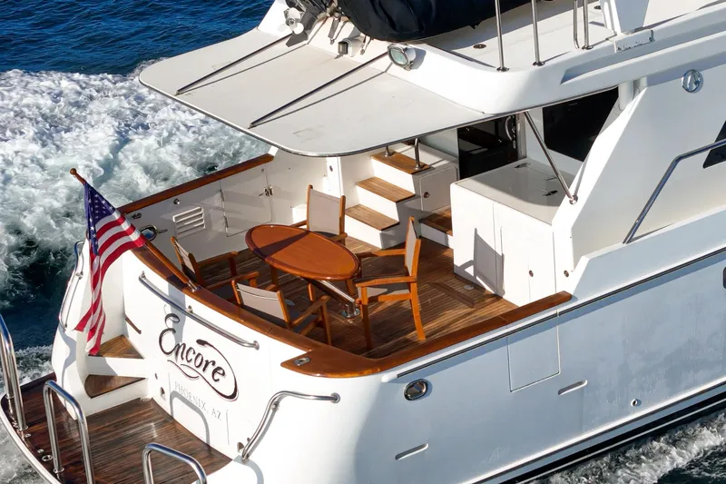 Encore Yacht Photos Pics Luxury 2006 Ocean Alexander 64 Pilothouse yacht with elegant deck and American flag.